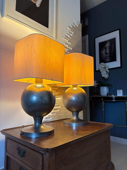 lampade vintage design space age con base sferica in ottone e paralume arancione luminescente su comodino in legno