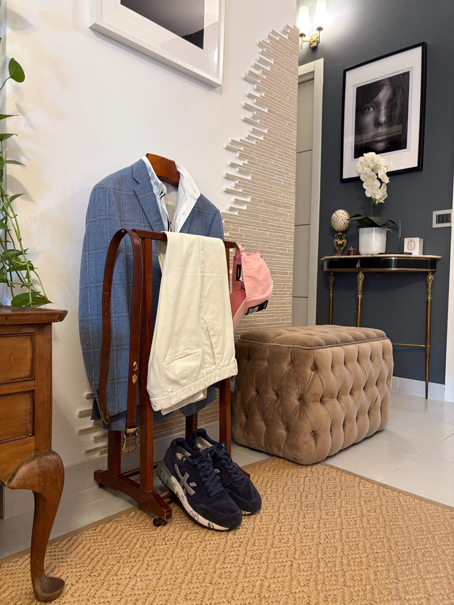 Fratelli Reguitti valet stand vintage in legno con giacca blu, pantaloni bianchi e scarpe sportive in interno elegante