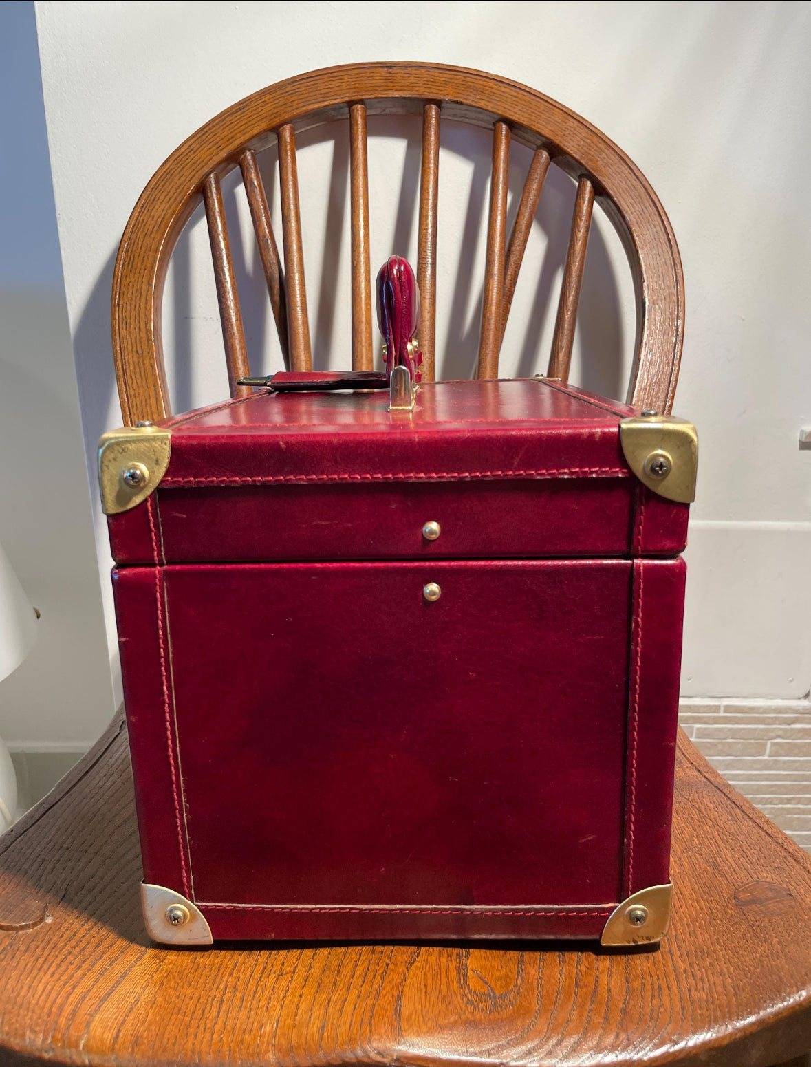 Scatola porta gioielli vintage italiana in pelle rossa con angoli rinforzati in metallo dorato, design elegante e funzionale per organizzare gioielli pregiati.