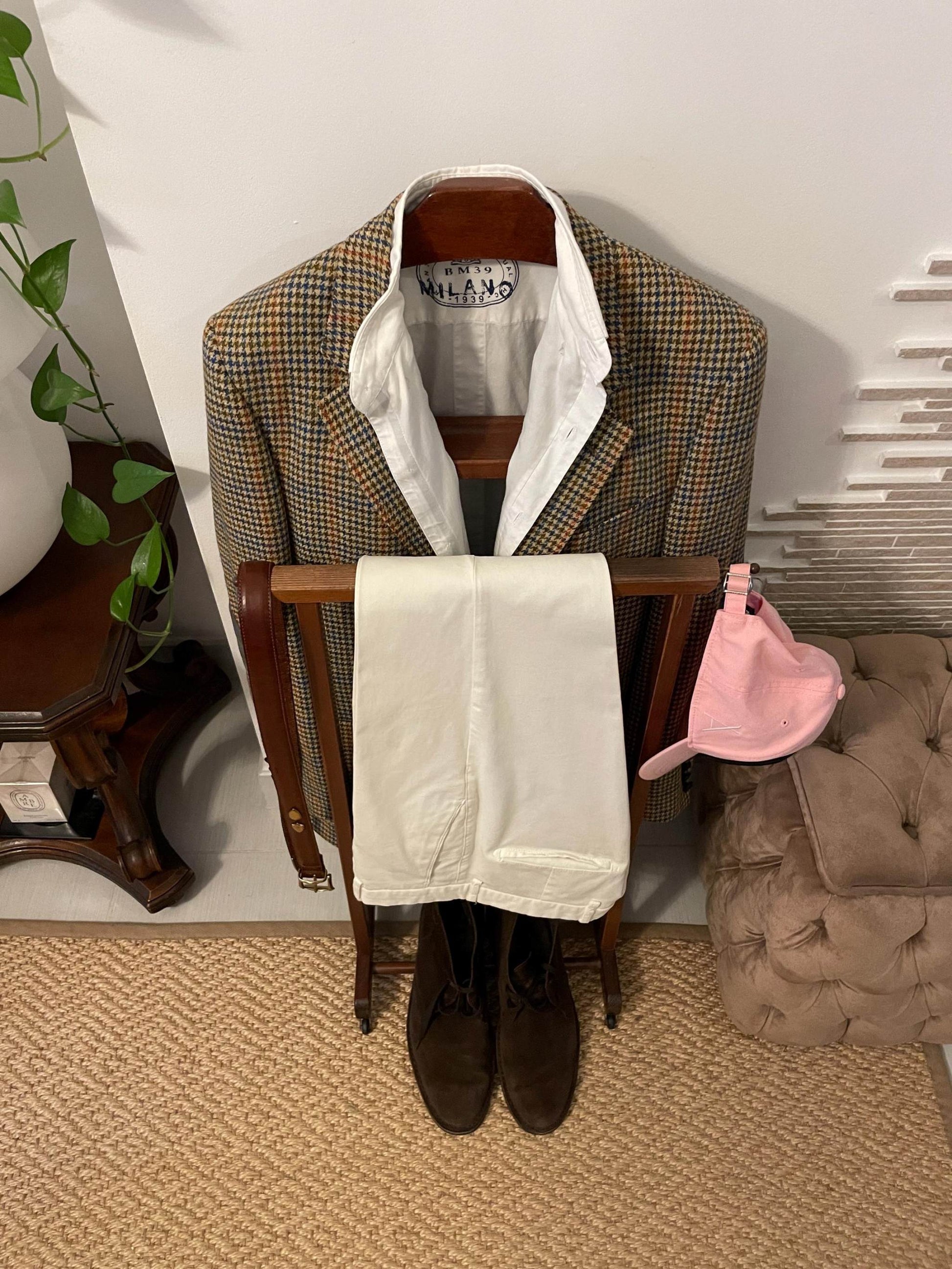 Attaccapanni vintage in legno italiano con giacca classica, pantaloni bianchi e cappellino rosa su stand valet elegante