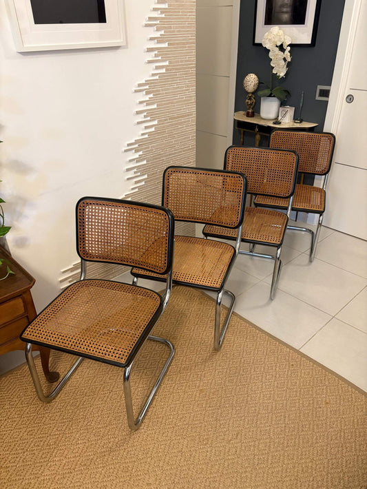 Set of four vintage Marcel Breuer Thonet chairs with tubular steel frames and woven cane seats in a modern interior setting
